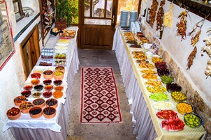 A buffet table with a variety of food items and a patterned rug.