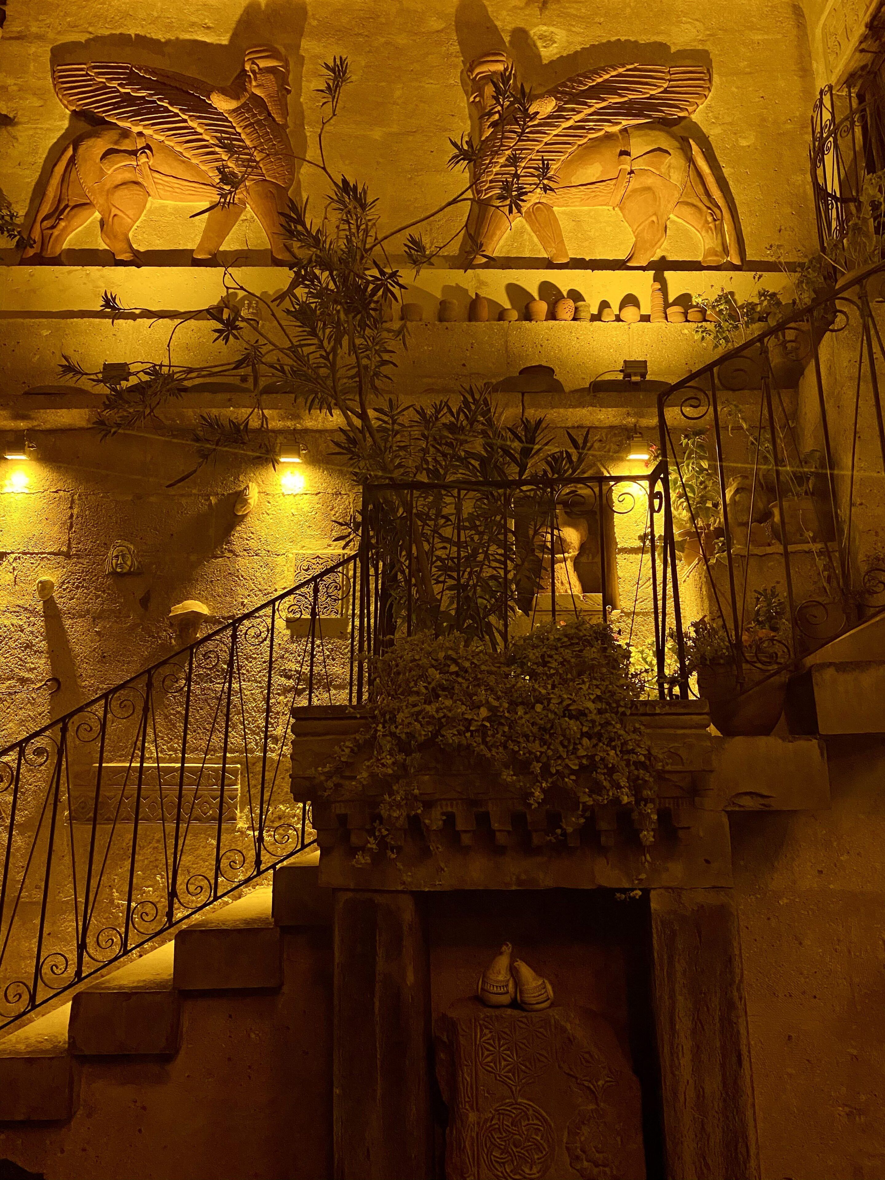 A staircase with ornate metal railings, stone steps, and decorative wall carvings.