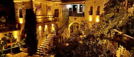 Stroll through the historic courtyard, surrounded by lush greenery and ornate balconies.