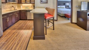 A hotel room with a kitchenette, a bed, a TV, and a bathroom. - Staybridge Suites Lubbock South by IHG (Lubbock)