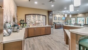 A modern kitchen with a central island, built-in appliances, and a stone backsplash. - Staybridge Suites Lubbock South by IHG (Lubbock)