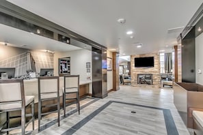 A modern hotel lobby with a reception desk, seating area, and a stone fireplace. - Staybridge Suites Lubbock South by IHG (Lubbock)