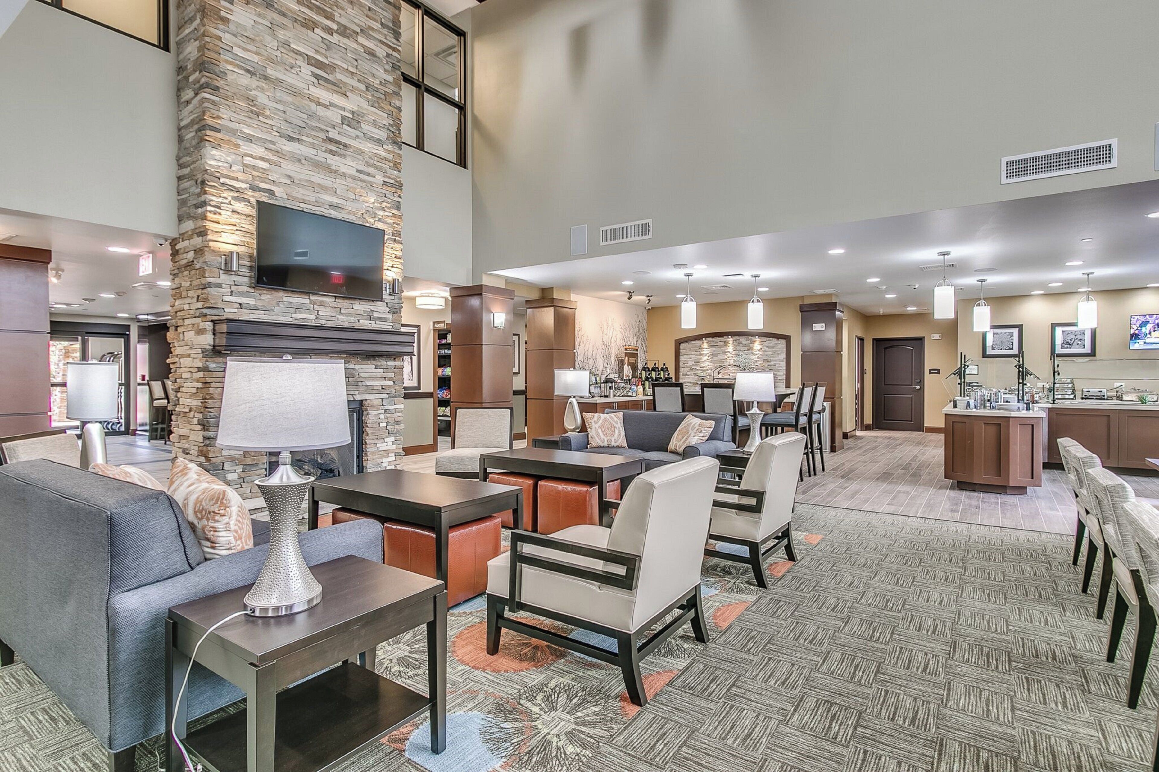 Een hotel lobby met een accentmuur van steen, een flatscreen televisie en een open haard.