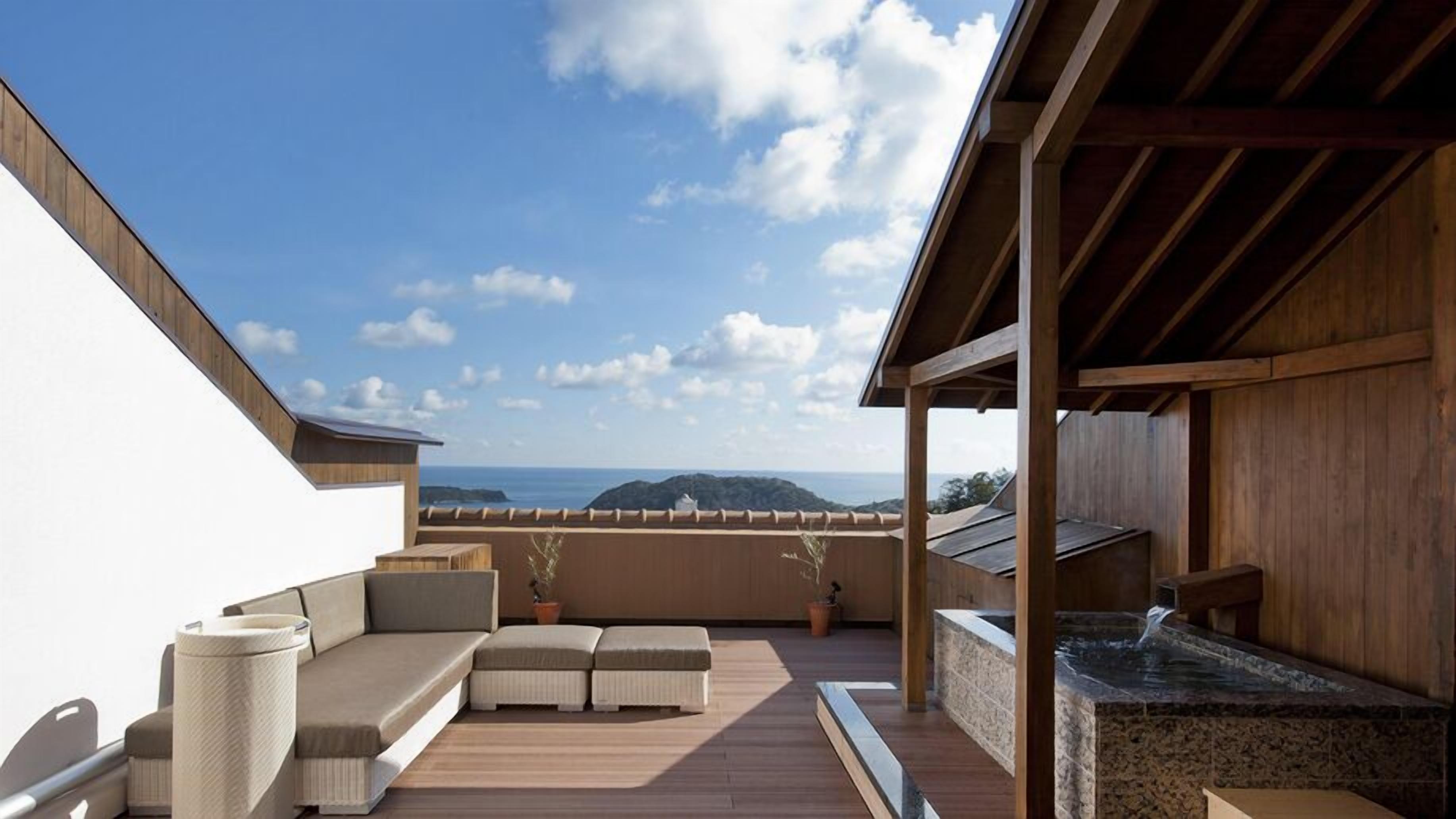 Une terrasse sur le toit avec un espace salon, un jacuzzi et une vue sur l’océan.