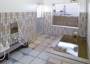 Une salle de bain moderne dotée d’une grande fenêtre, d’une baignoire et d’un espace douche.