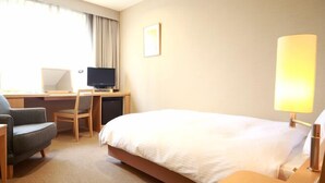 A hotel room with a bed, a desk with a chair, a television, and a lamp. - Hotel Brillante Musashino (Saitama)