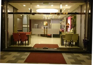 A hotel lobby with a reception desk, seating area, and a chandelier. - Camelot Inn (Hualien City)