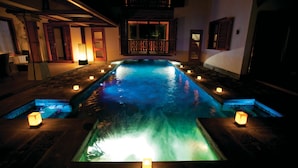 A nighttime swimming pool with water features and candles. - Sankhara Beachfront Villas (Poste Lafayette)