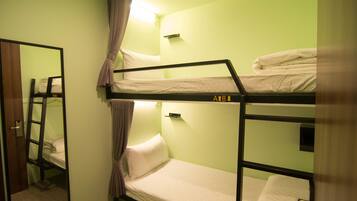 A bunk bed room with a ladder, a mirror, and a light fixture.