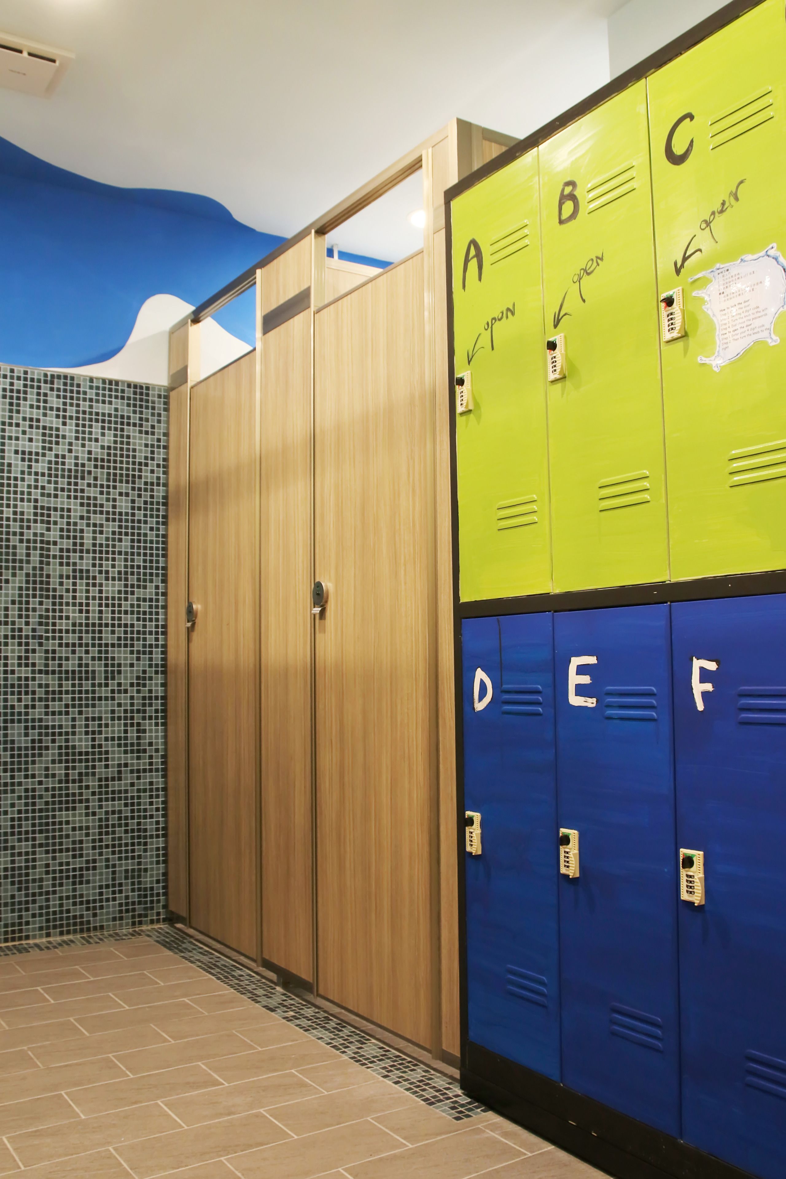 Un conjunto de casilleros con las letras A, B, C, D, E y F, y una puerta de madera con un revestimiento de azulejos.