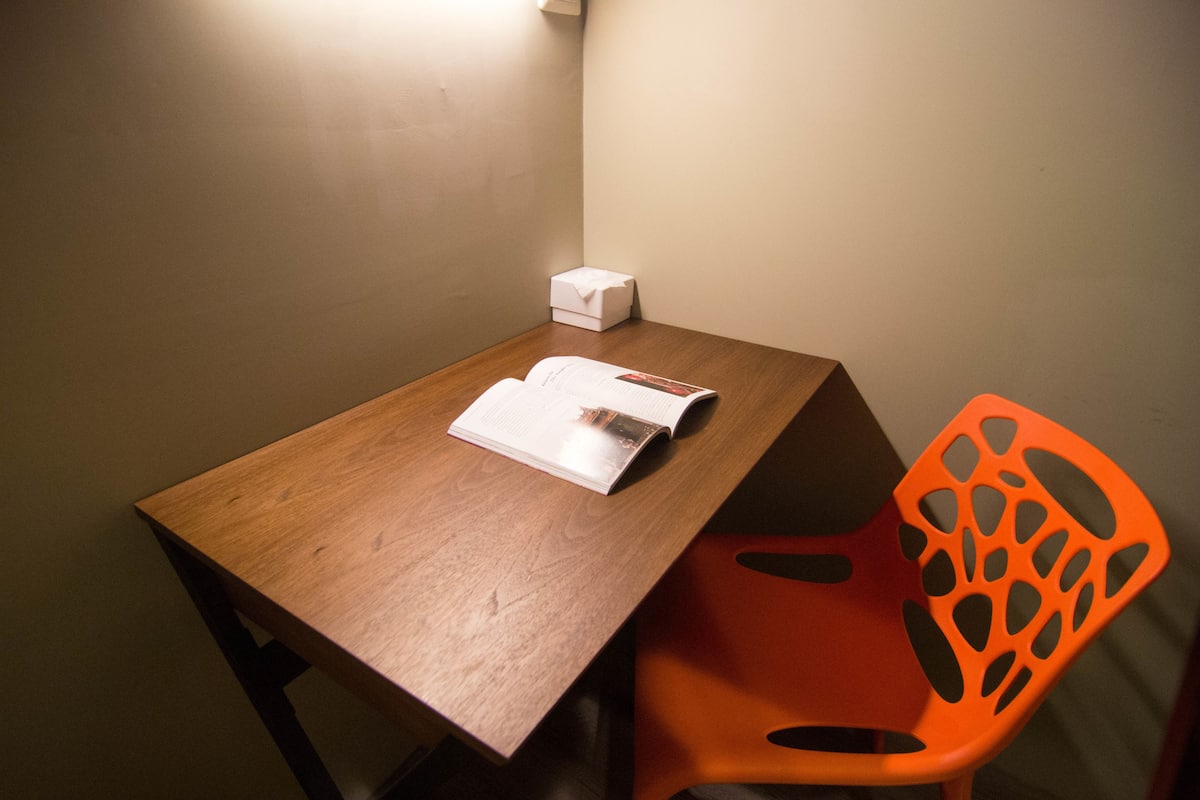 A wooden table with a white box and a magazine.
