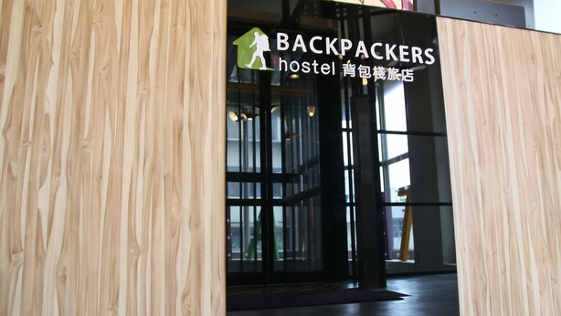 Une structure en bois sur laquelle est apposée une enseigne indiquant qu’il s’agit d’une auberge de jeunesse.