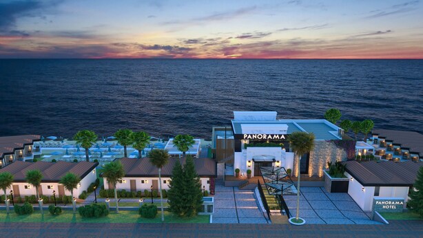 Un hôtel au design moderne, doté d’une entrée imposante, d’un espace extérieur aménagé et offrant une vue sur la mer.