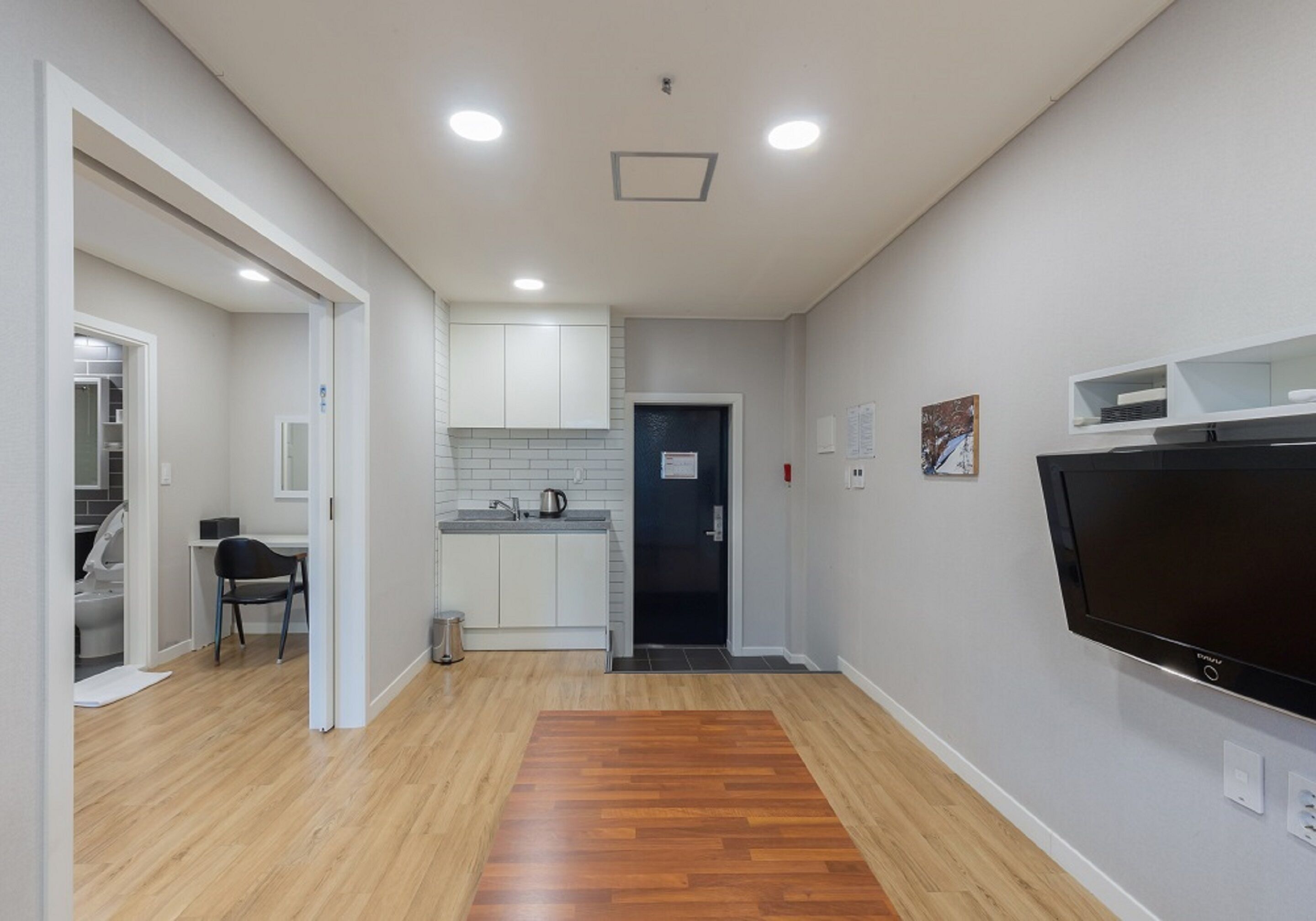 A modern kitchen with white cabinets, a black countertop, and a built-in oven.