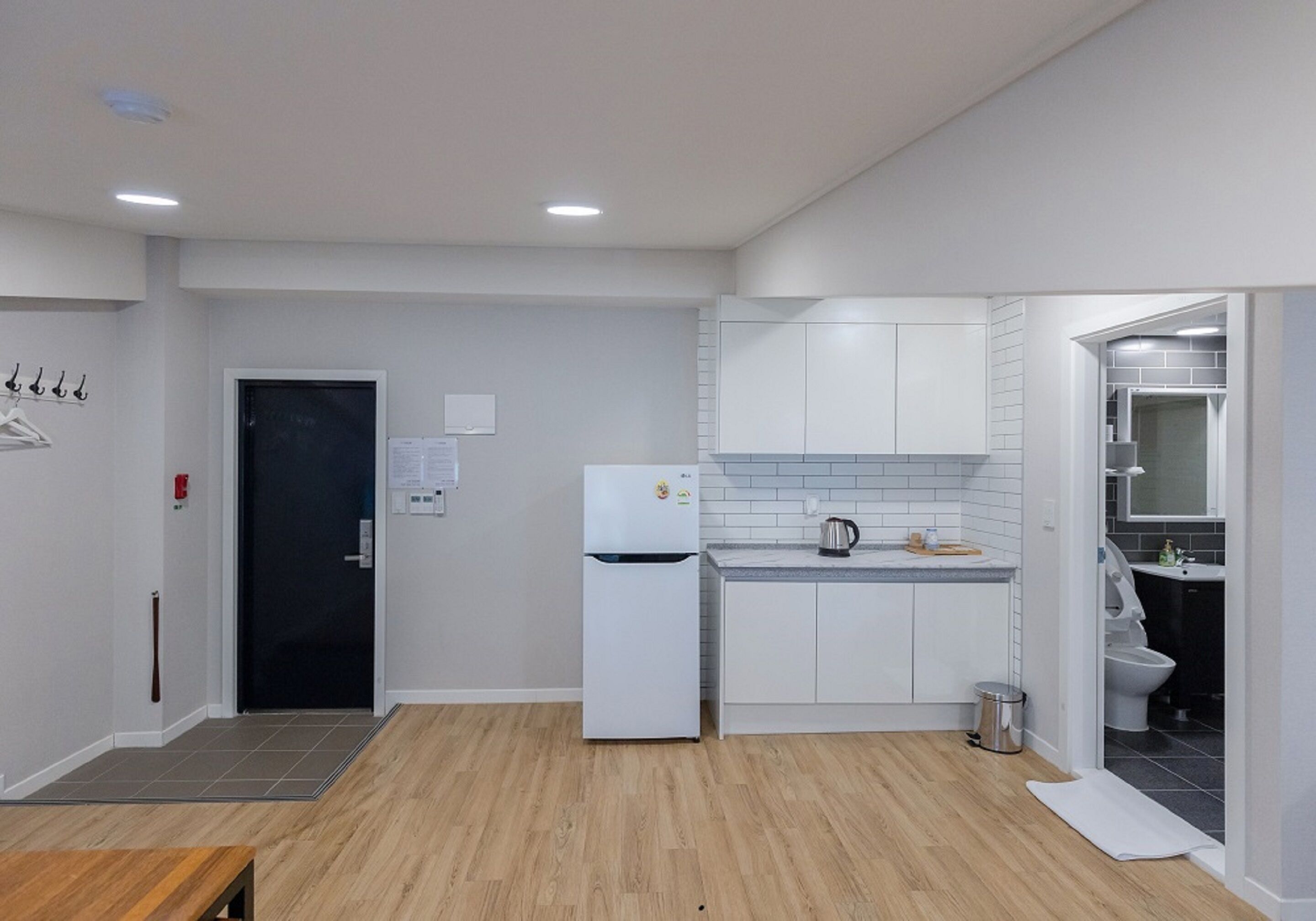 A modern kitchen with white cabinets, a refrigerator, and a sink.