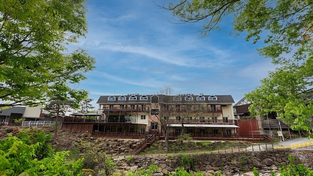 Un hotel de varios pisos con estilo arquitectónico tradicional, con balcones y fachada de piedra.