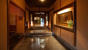 A traditional Japanese hallway with tatami flooring, wooden beams, and a hanging lantern. - Yoyokaku (Karatsu)