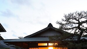 A traditional Japanese house with a wooden exterior, a tiled entrance, and a stone pathway leading to the door. - Yoyokaku (Karatsu)
