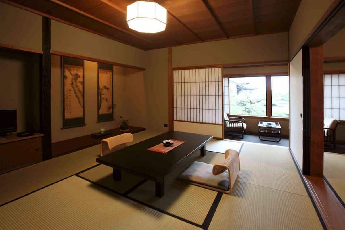 A traditional Japanese room with tatami flooring, a low table, and sliding doors.