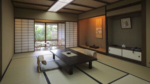 A traditional Japanese room with tatami flooring, a low table, and sliding doors. - Yoyokaku (Karatsu)