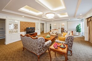 A spacious living room with a large sofa, a coffee table, and a television. - Muong Thanh Luxury Moc Chau (Thao Nguyen)