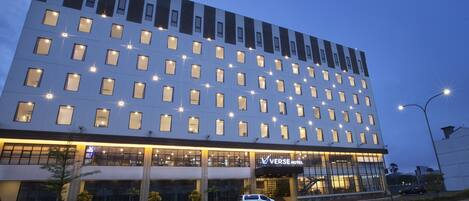 A modern hotel with multiple floors, large windows, and a prominent entrance.