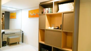 Een moderne badkamer met een wastafelmeubel, een bankje en een grote plank met boeken en toiletartikelen.
