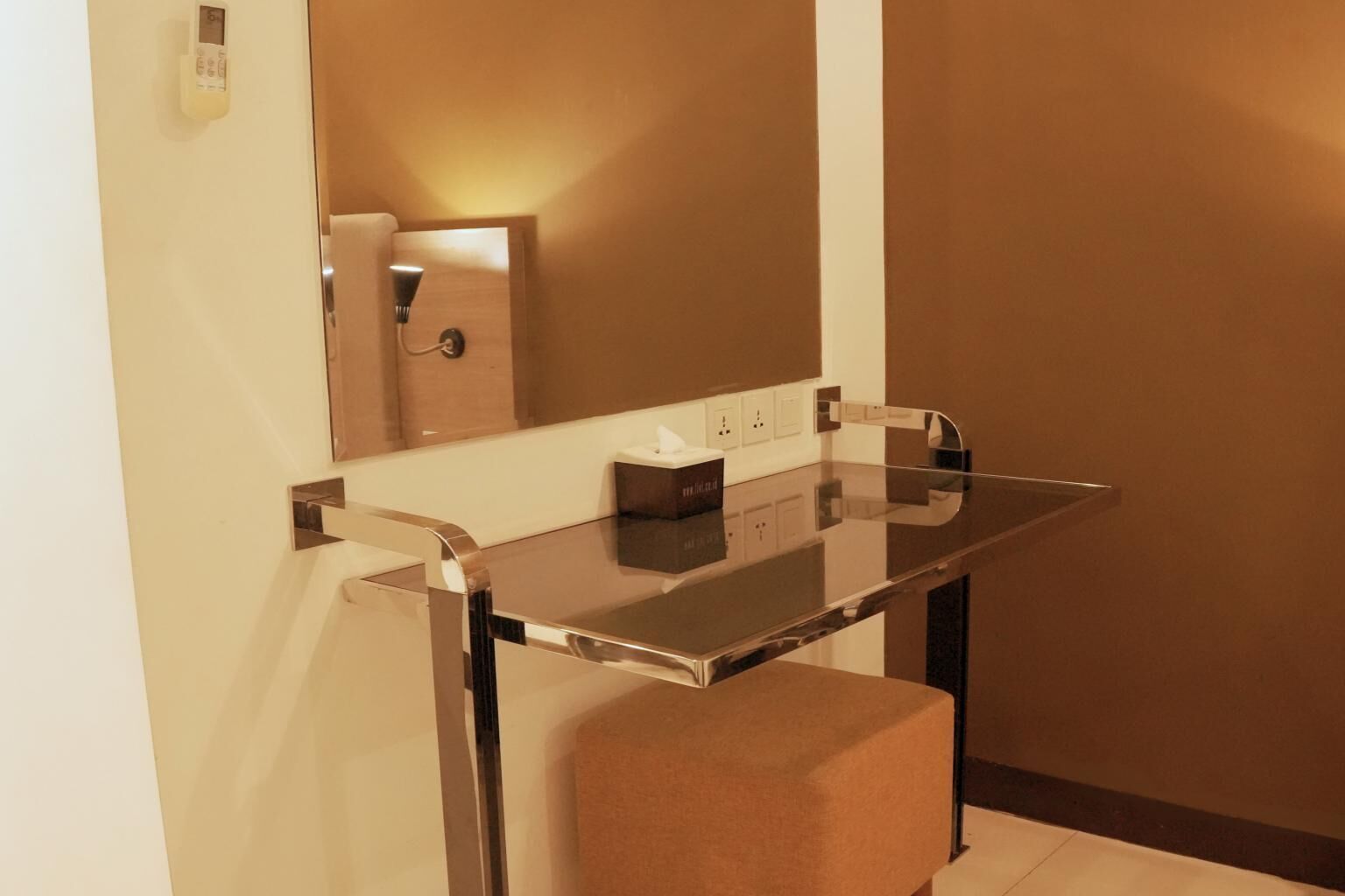 A modern bathroom with a glass vanity, a towel rack, and a mirror.