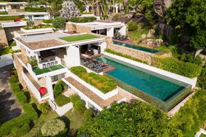A modern villa with a rooftop pool, lush greenery, and a stone facade. - Samujana Villas (Koh Samui)