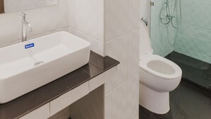 A bathroom with a white sink, a toilet, and a glass shower enclosure. - No.9 Hostel (Chiang Mai)