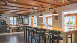 Una cocina moderna con una encimera larga, taburetes de bar y una cafetera.