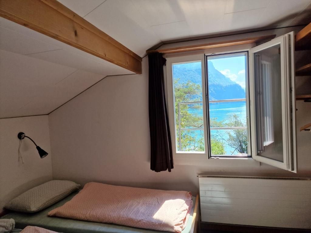 Une chambre avec un lit, une fenêtre donnant sur la mer et un radiateur.