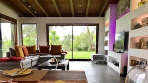Un salon moderne avec un canapé, une table basse et un coin repas.