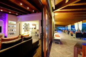 An indoor-outdoor living area with a sofa, a dining table, and chairs. - Borgo del Nespolo (Peschici)