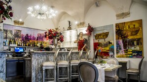 Un restaurant doté d’un bar, de tabourets de bar en marbre et d’une table à manger avec des chaises.