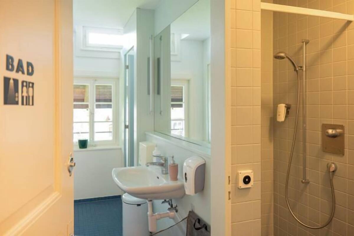 Ein Badezimmer mit Waschbecken, Spiegel und Dusche.