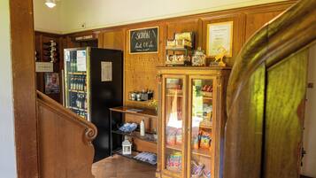 Una escalera de madera con un refrigerador y estanterías al fondo.