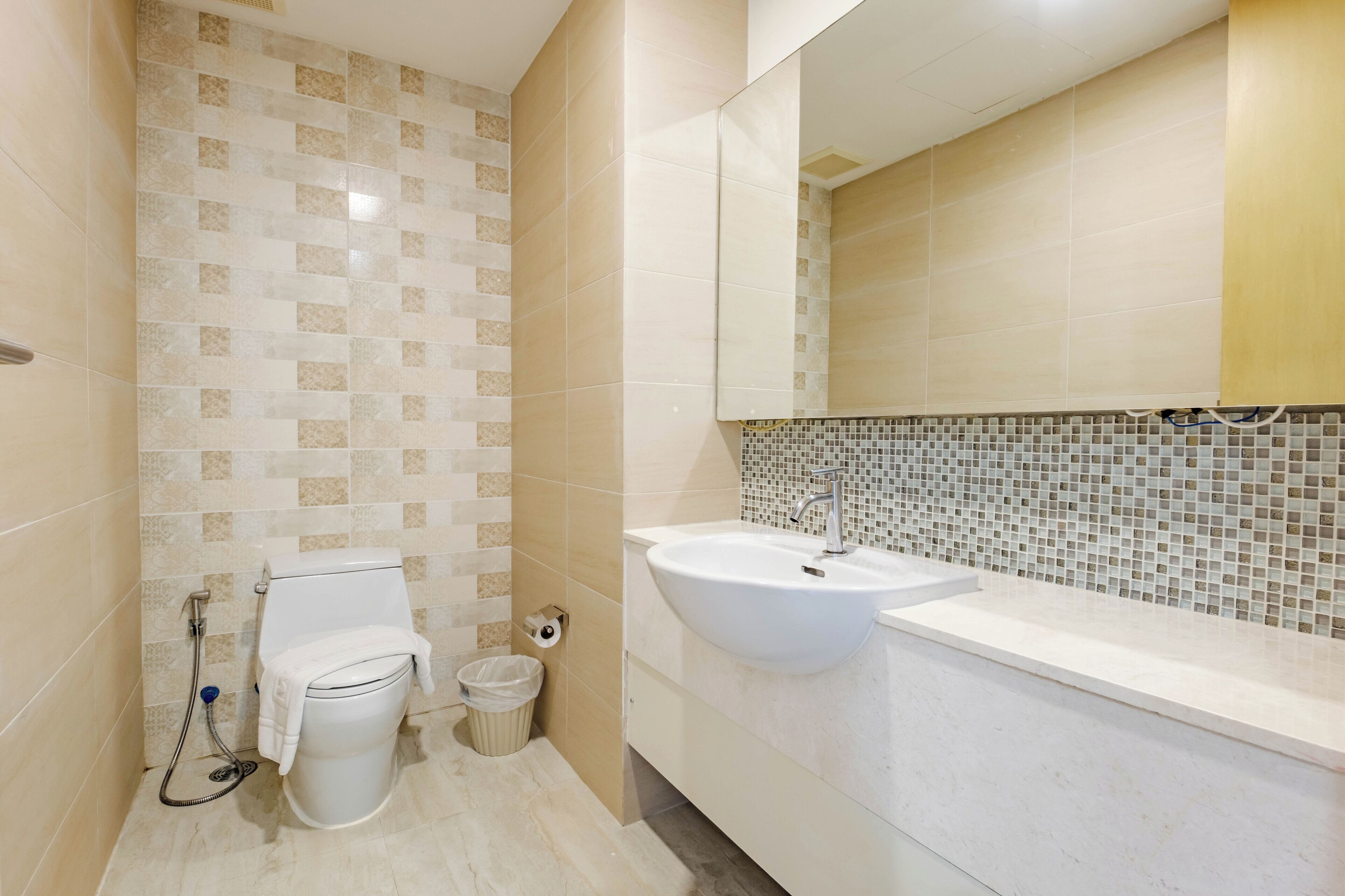Un baño con inodoro, bidé, lavamanos y paredes de azulejos.