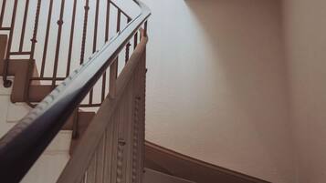 Una escalera con barandillas de madera y una pared lisa.