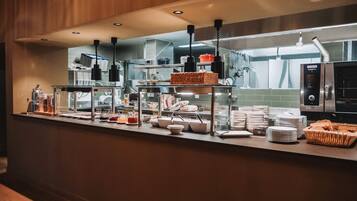 A buffet setup with various food items and serving utensils.