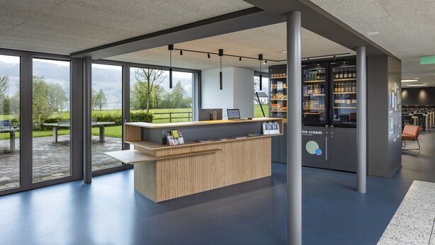 A modern reception area with a wooden counter, large windows, and a view of the outdoors. - Youth Hostel Rapperswil-Jona (Rapperswil-Jona)