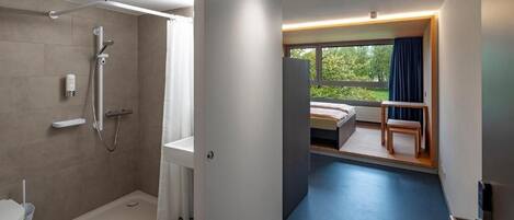 A modern bathroom with a shower, toilet, and sink.
