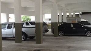 Un'area di parcheggio con pilastri in cemento e alcune auto.