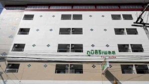 Un edificio a più piani con facciata bianca e numerose finestre.