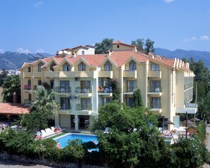 A multi-story hotel with a swimming pool, balconies, and a mountainous backdrop. - Sinem Hotel & Apart (Marmaris)
