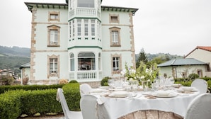 A large, light-colored building with a balcony and a dining area set up outside. - El Solar del Mazo (Voto)