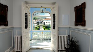 An open doorway leading to a conservatory with a view of a garden and buildings. - El Solar del Mazo (Voto)