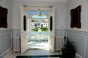 Un umbral abierto que da a un invernadero con vistas a un jardín y edificios.