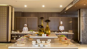 A buffet setup with multiple food stations, chefs present, and a modern interior design. - Muong Thanh Luxury Vientiane (Vientiane)