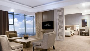 A modern hotel room with a large window, a flat-screen TV, a bed, a desk, and a seating area. - Muong Thanh Luxury Vientiane (Vientiane)